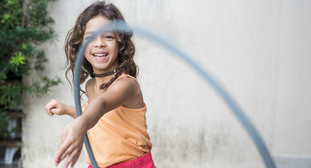 Young girl playing with a hula hoop