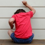 Kid banging their fist against a wall