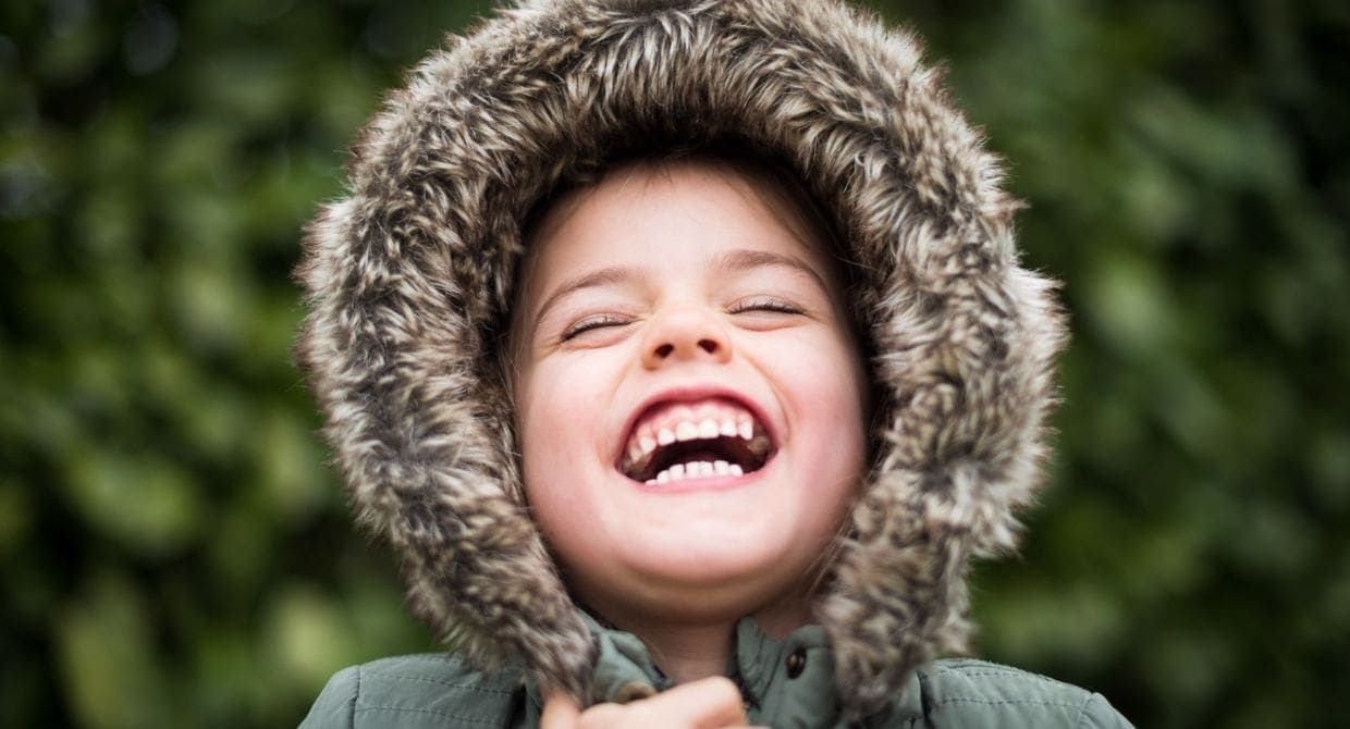 Child in winter coat laughing