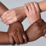 White hands and black hands hold each other