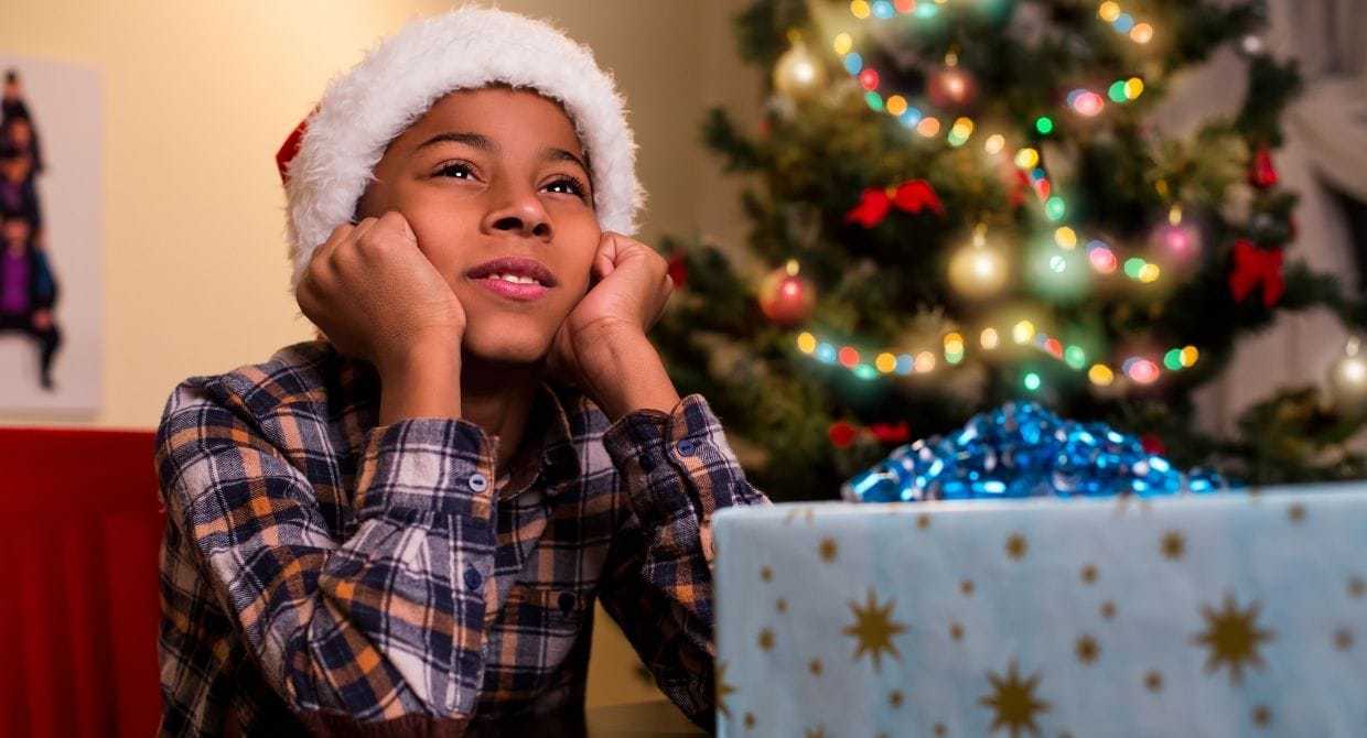 young boy dreaming about christmas in a santa hat