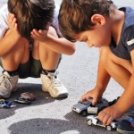 two young boys playing with cars