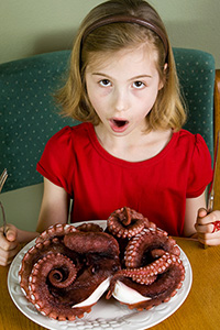 Young girl eating Octopus dinner